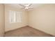 Bright, minimalist bedroom with neutral walls, tile floor, plantation shutters, and a ceiling fan at 10572 E Tierra Buena Ln, Scottsdale, AZ 85255
