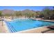 Large community pool with mountain views, surrounded by lounge chairs and well-maintained landscaping at 10572 E Tierra Buena Ln, Scottsdale, AZ 85255