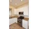 Charming kitchen featuring white cabinetry, stainless steel appliances, and durable tile flooring at 10572 E Tierra Buena Ln, Scottsdale, AZ 85255