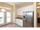 Modern kitchen with stainless steel refrigerator, white cabinets, granite countertops and tile floors at 10572 E Tierra Buena Ln, Scottsdale, AZ 85255
