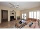 Open concept living room featuring fireplace, travertine floors, and access to the patio at 10572 E Tierra Buena Ln, Scottsdale, AZ 85255