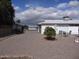 View of the backyard with white home and fruit tree, including seating area and mature landscaping at 10607 W El Rancho Dr, Sun City, AZ 85351