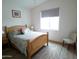 Bright bedroom with wooden bed frame, colorful quilt, neutral rug, and a large window at 1127 N Sherwood Way, Queen Valley, AZ 85118