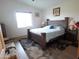 Bedroom featuring a dark wood bed frame, neutral rug, and bright natural light at 1127 N Sherwood Way, Queen Valley, AZ 85118