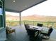 Relaxing covered deck showcasing a patio table with chairs overlooking the golf course and mountain views at 1127 N Sherwood Way, Queen Valley, AZ 85118