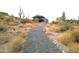 Charming hillside home featuring a gravel pathway and native desert vegetation at 1127 N Sherwood Way, Queen Valley, AZ 85118