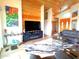 Bright living room with wood-paneled walls and ceilings, modern furnishings, and decorative fireplace at 1127 N Sherwood Way, Queen Valley, AZ 85118