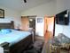Spacious bedroom with sliding barn door to ensuite bathroom, wooden bed, and a seating area at 1127 N Sherwood Way, Queen Valley, AZ 85118