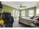 This bedroom features green walls, multiple windows, a ceiling fan, and a desk with drawers at 12956 N 152Nd Ave, Surprise, AZ 85379