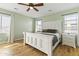 This bedroom features light green walls, a ceiling fan, and a white bed frame with light-colored wood floors at 12956 N 152Nd Ave, Surprise, AZ 85379