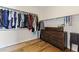 Well-organized walk-in closet with ample hanging space, wooden dresser, and hardwood floors at 12956 N 152Nd Ave, Surprise, AZ 85379
