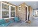 Cozy front porch with brick accents, featuring charming seating and a welcoming entrance at 12956 N 152Nd Ave, Surprise, AZ 85379