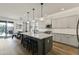 Bright kitchen with an island, bar stool seating, modern lighting, and stainless steel appliances and light-colored cabinets at 12956 N 152Nd Ave, Surprise, AZ 85379