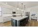 A modern kitchen features an island with barstool seating, stainless steel appliances, and white cabinetry at 12956 N 152Nd Ave, Surprise, AZ 85379