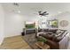 A cozy living room features a plush sectional sofa, a ceiling fan, recessed lighting, and a modern entertainment center at 12956 N 152Nd Ave, Surprise, AZ 85379