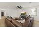 A cozy living room features a plush sectional sofa, a ceiling fan, recessed lighting, and a modern entertainment center at 12956 N 152Nd Ave, Surprise, AZ 85379