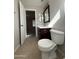 This bathroom features a toilet, cabinet, a dark framed mirror, and a view to the bedroom at 1304 S Owl Dr, Gilbert, AZ 85296