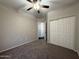 Bedroom featuring neutral walls and plush carpeting, ceiling fan, closet, and an adjoining bathroom at 1304 S Owl Dr, Gilbert, AZ 85296