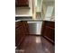 A stainless steel dishwasher is surrounded by dark wood cabinetry and stylish hardwood floors at 1304 S Owl Dr, Gilbert, AZ 85296