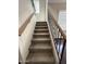 Carpeted stairway with wood and wrought iron railing, ascending toward bright natural light at 1304 S Owl Dr, Gilbert, AZ 85296