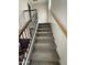 Carpeted stairway with wood and wrought iron railing, descending to the living space at 1304 S Owl Dr, Gilbert, AZ 85296