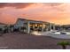 Expansive backyard featuring a covered patio with outdoor furniture, a pool, a hot tub, and desert landscaping at 13616 W Junipero Dr, Sun City West, AZ 85375