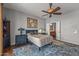 This bedroom features a ceiling fan, a large area rug, and an ensuite bathroom at 13616 W Junipero Dr, Sun City West, AZ 85375