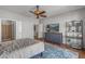 Bedroom features a ceiling fan, a TV on a dresser, and an ensuite bathroom and laundry room at 13616 W Junipero Dr, Sun City West, AZ 85375