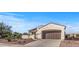Attractive home with desert landscaping, an arched entryway, a two-car garage, and solar panels on the roof at 13616 W Junipero Dr, Sun City West, AZ 85375