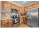 Charming kitchen boasting stainless steel appliances, stylish backsplash, and warm wood cabinets at 13616 W Junipero Dr, Sun City West, AZ 85375