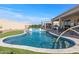 Backyard pool with water feature, covered patio, outdoor living space and artificial grass at 13616 W Junipero Dr, Sun City West, AZ 85375