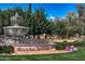 Water feature in front of Corte Bella sign surrounded by green grass and landscaping at 13616 W Junipero Dr, Sun City West, AZ 85375