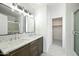 Bright bathroom features a double sink vanity, modern fixtures, and a walk-in closet entrance at 14398 W Marcus Dr, Surprise, AZ 85374