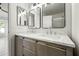 Bathroom featuring double sinks, quartz countertops and modern fixtures with two large mirrors at 14398 W Marcus Dr, Surprise, AZ 85374