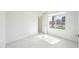 Sun-filled bedroom with fresh paint, tile floors, and a large window with neighborhood views at 14398 W Marcus Dr, Surprise, AZ 85374