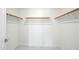 Walk-in closet with white walls, tile floor, and multiple wooden rods for ample storage at 14398 W Marcus Dr, Surprise, AZ 85374