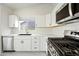 Modern kitchen with stainless steel appliances, white cabinets, and beautiful countertop space at 14398 W Marcus Dr, Surprise, AZ 85374
