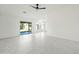 Bright, open living room with tile floors, ceiling fan, and a large glass sliding doors at 14398 W Marcus Dr, Surprise, AZ 85374