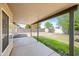 A covered patio overlooks a spacious backyard with lush green grass and block wall for privacy at 14398 W Marcus Dr, Surprise, AZ 85374