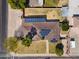 Aerial view of a single-story house featuring a well-maintained lawn and a roof equipped with solar panels at 1610 E Mclellan Rd, Mesa, AZ 85203