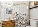 Well-lit bathroom with a floral curtain over the shower and neutral-colored tiling at 1610 E Mclellan Rd, Mesa, AZ 85203
