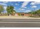 Charming brick home featuring a well-manicured lawn, solar panels, and mature trees on a sunny day at 1610 E Mclellan Rd, Mesa, AZ 85203