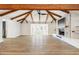 Open living room with high vaulted ceilings, wooden beams, a fireplace, and modern flooring at 1610 E Mclellan Rd, Mesa, AZ 85203