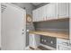 Functional mudroom features built in desk, cabinets, and access door at 16232 W Montoya Dr, Surprise, AZ 85374