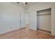 This bedroom has wood floors, a ceiling fan, and an open closet at 1713 S 117Th Dr, Avondale, AZ 85323