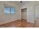 This bedroom has wood floors, a window with a view, and an open closet at 1713 S 117Th Dr, Avondale, AZ 85323
