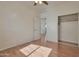 A simple bedroom boasts wood floors, a ceiling fan, and an open closet at 1713 S 117Th Dr, Avondale, AZ 85323