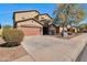 Charming two-story home showcasing a brown exterior, spacious driveway, and drought-resistant landscaping at 1713 S 117Th Dr, Avondale, AZ 85323