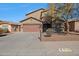 Charming two-story home showcasing a brown exterior, spacious driveway, and well-maintained landscaping at 1713 S 117Th Dr, Avondale, AZ 85323