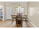 Cozy dining room with wood floors, a bright window, and a modern light fixture above the table at 17741 W Port Royale Ln, Surprise, AZ 85388